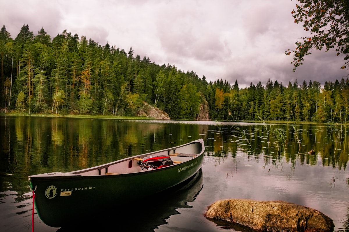 Finnish lake with canoe surrounded by lush green forest