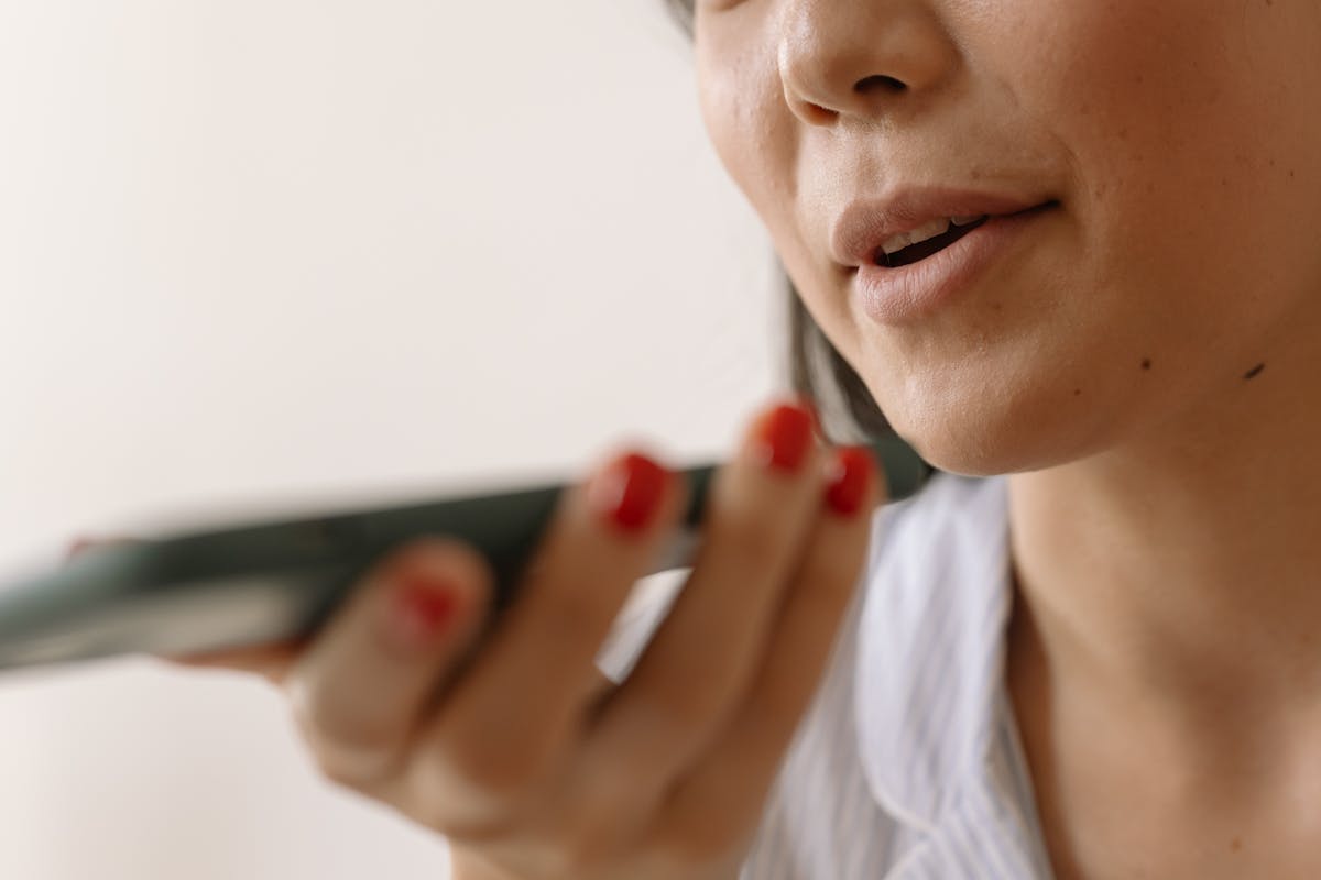 Woman wearing headphones and using a microphone for podcast or voice recording