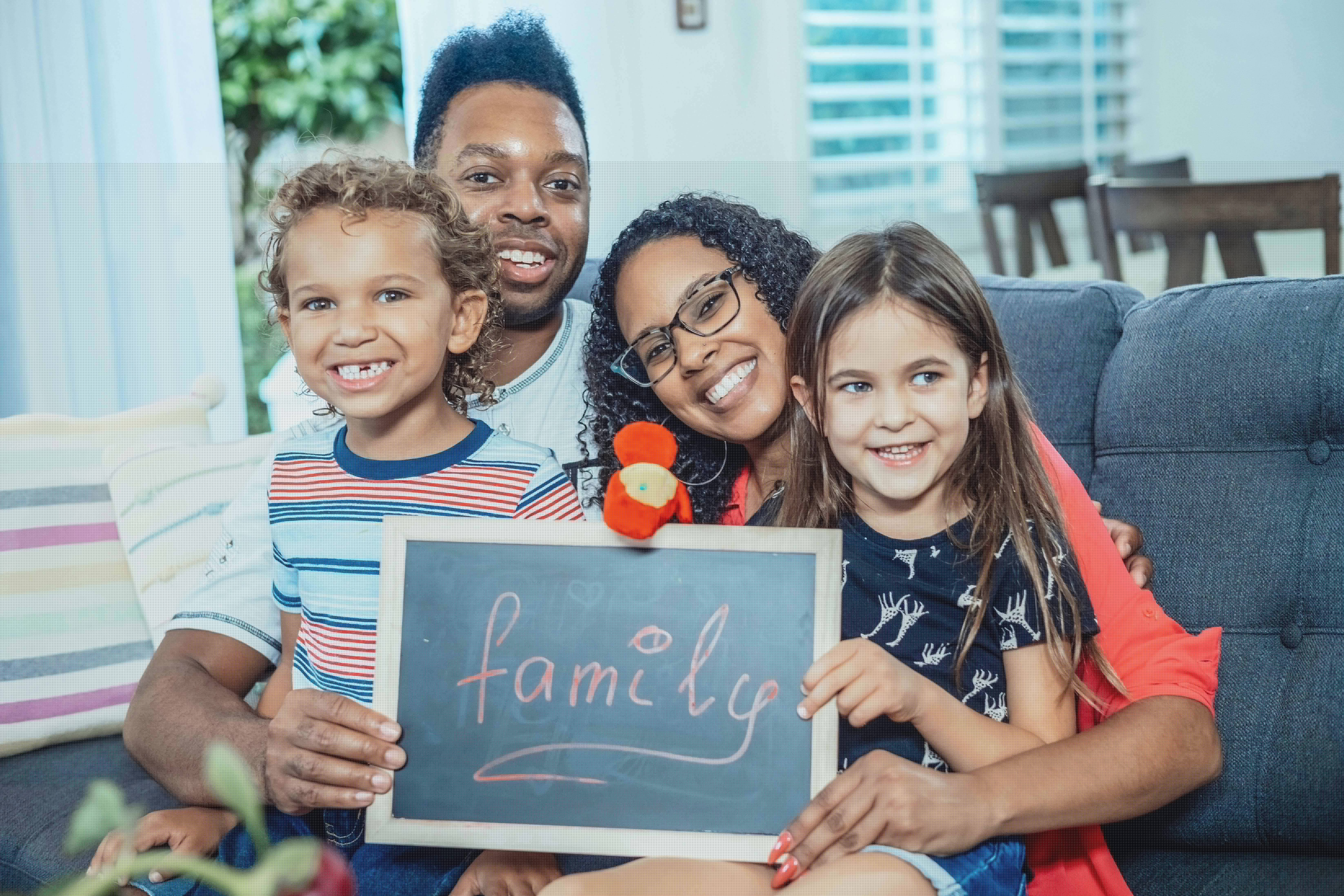 Multicultural family spending time together on a couch at home