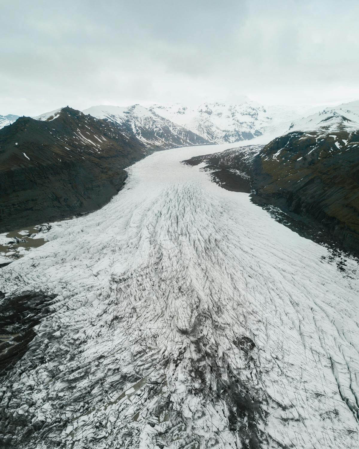 Snow-covered Icelandic mountain range under winter sky