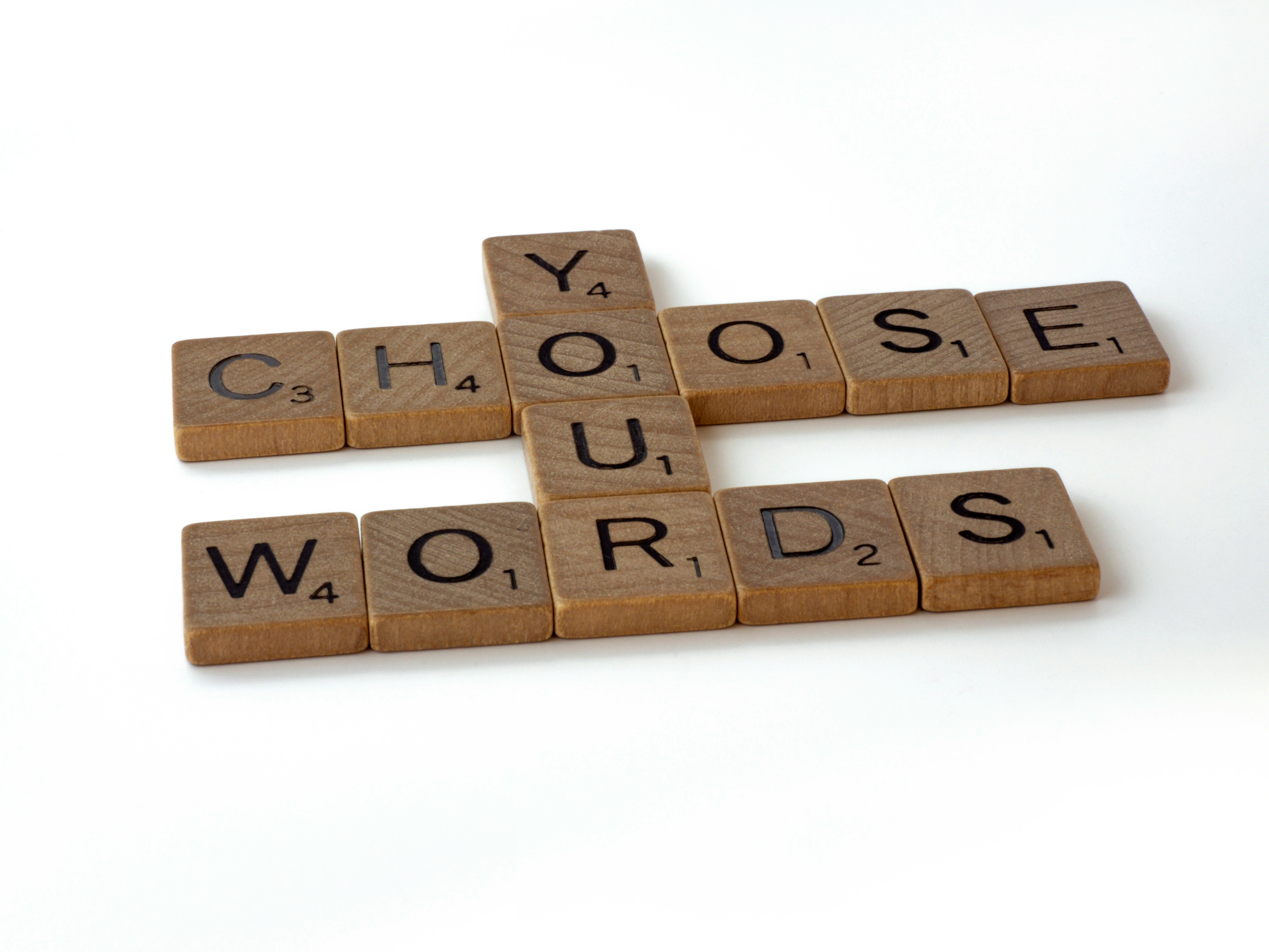 Wooden letter tiles spelling "choose your words"